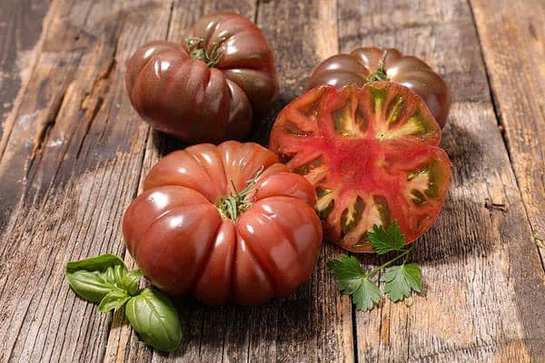 Weibchen teilen Tomate auf dem Tisch