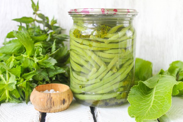 zelené fazolky s bylinkami ve sklenici 